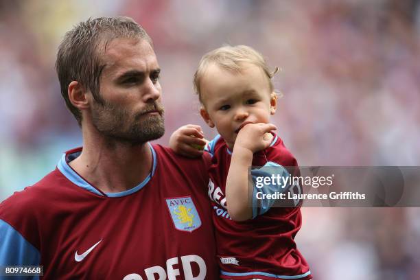Olof Mellberg of Aston Villa holds his child as he walks out for the last time at Villa Park during the Barclays Premier League match between Aston...