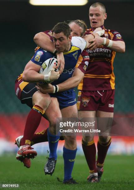 Andy Bracek of Warrington is tackled by Eorl Crabtree and Kevin Brown of Huddersfield during the engage Super League "Millennium Magic" match between...