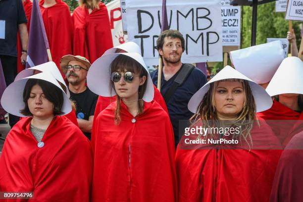 Woman dressed as as characters from The Handmaid's Tale and people holding anti-Trump posters and banners are seen in Warsaw, Poland on 6 July 2017...