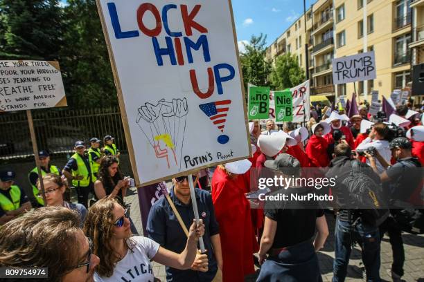 Woman dressed as as characters from The Handmaid's Tale and people holding anti-Trump posters and banners are seen in Warsaw, Poland on 6 July 2017...