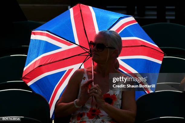 Spectator shields themselves from the sun on day four of the Wimbledon Lawn Tennis Championships at the All England Lawn Tennis and Croquet Club on...