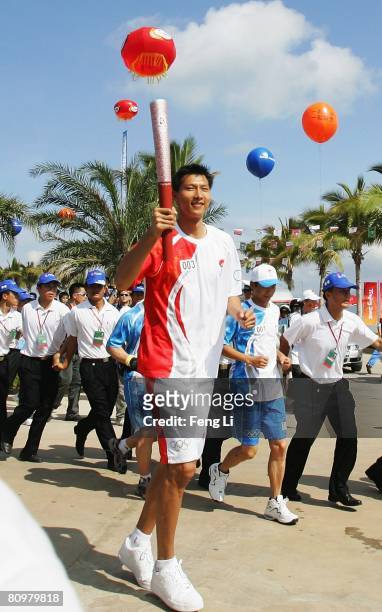 Chinese NBA basketball player Yi Jianlian carries the Olympic Torch during the launch ceremony of the Beijing Olympic torch relay in Phoenix Square...