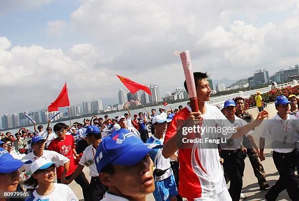 Chinese NBA basketball player Yi Jianlian carries the Olympic Torch during the launch ceremony of the Beijing Olympic torch relay in Phoenix Square...