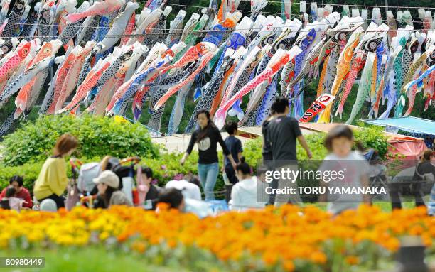 People enjoy colorful carp streamers being displayed at a park in Sagamihara, suburban Tokyo, on May 4, 2008 to celebrate Children's Day. Some 1,200...