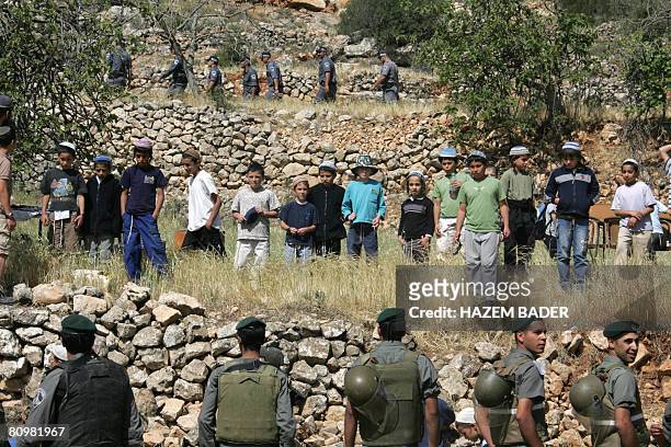 Israeli settlers try to prevent Israeli security forces from dismantling a makeshift Synagogue built in Palestinian land at the illegal outpost of...