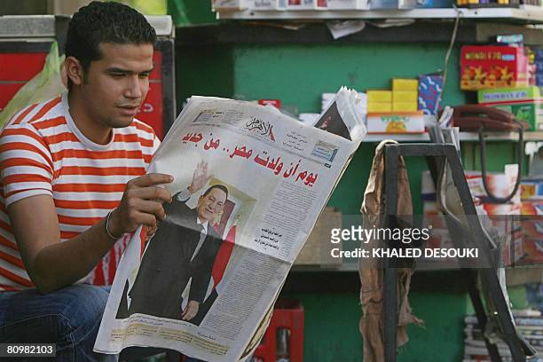 An Egyptian man reads a copy of Al-Ahram newspaper with a frontpage picture of President Hosni Mubarak reading "The day Egypt was born... Again" in...