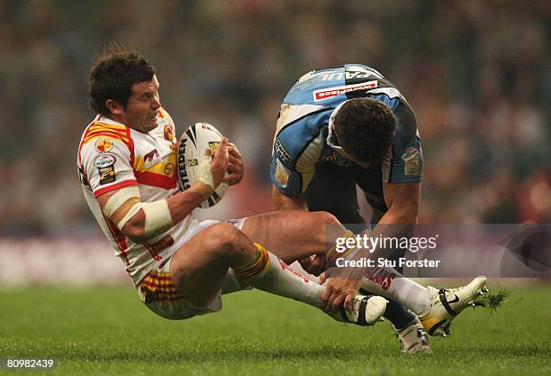 Clint Greenshields of Catalans is brought down by Henry Paul of Harlequins during the engage Super League "Millennium Magic" match between Catalans...