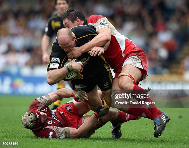 Lawrence Dallaglio of Wasps is tackled by Gareth Delve and Alasdair Strokosh during the Guinness Premiership match between London Wasps and...