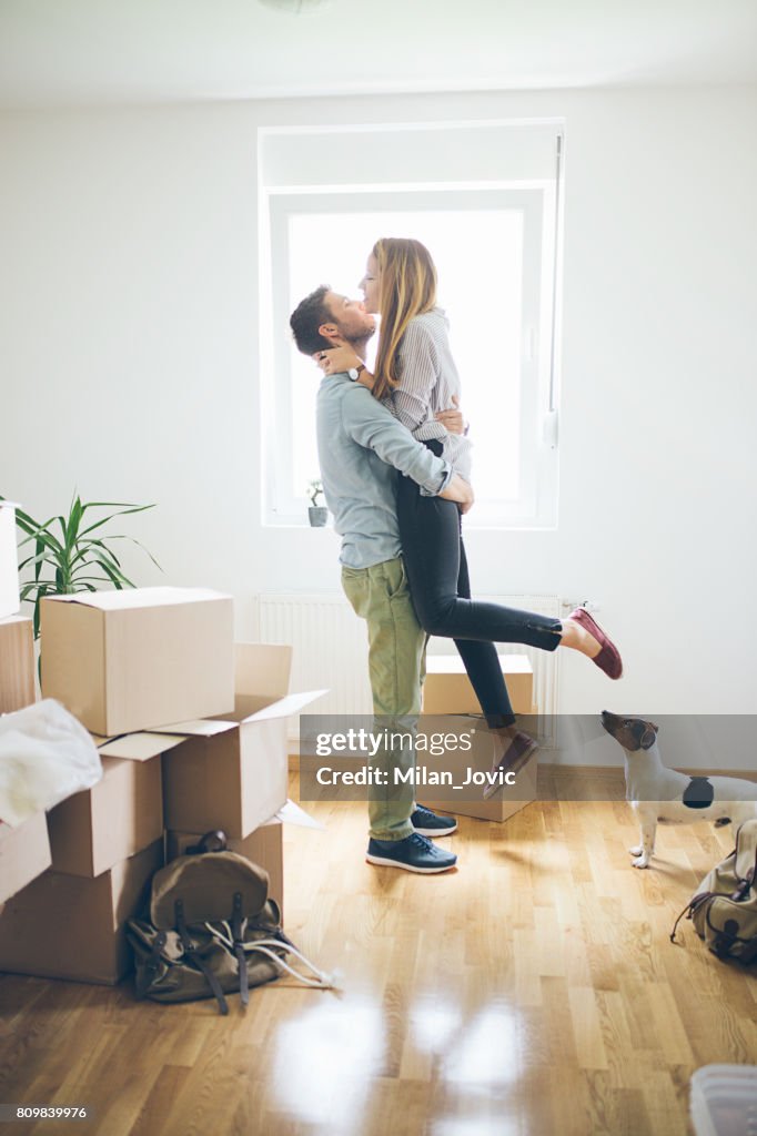 Happy man lifting woman in new house