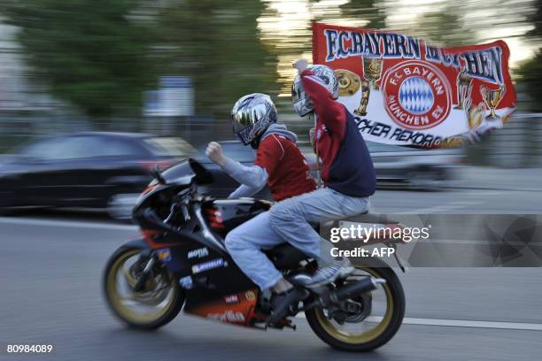 Supporters of Bayern Munich wave the flag of their club as they ride through the streets of Munich after the Wolfsburg vs Munich Bundesliga football...