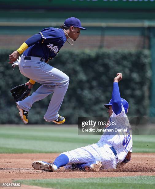 Orlando Arcia of the Milwaukee Brewers leaps over Jon Jay of the Chicago Cubs as he turns a double play in the 1st inning at Wrigley Field on July 6,...