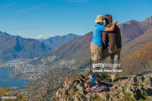 couple standing up together and enjoying the mountain view - locarno fotografías e imágenes de stock