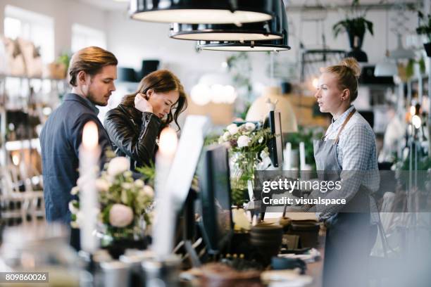 café scene with customers at till - retail boutique stock pictures, royalty-free photos & images