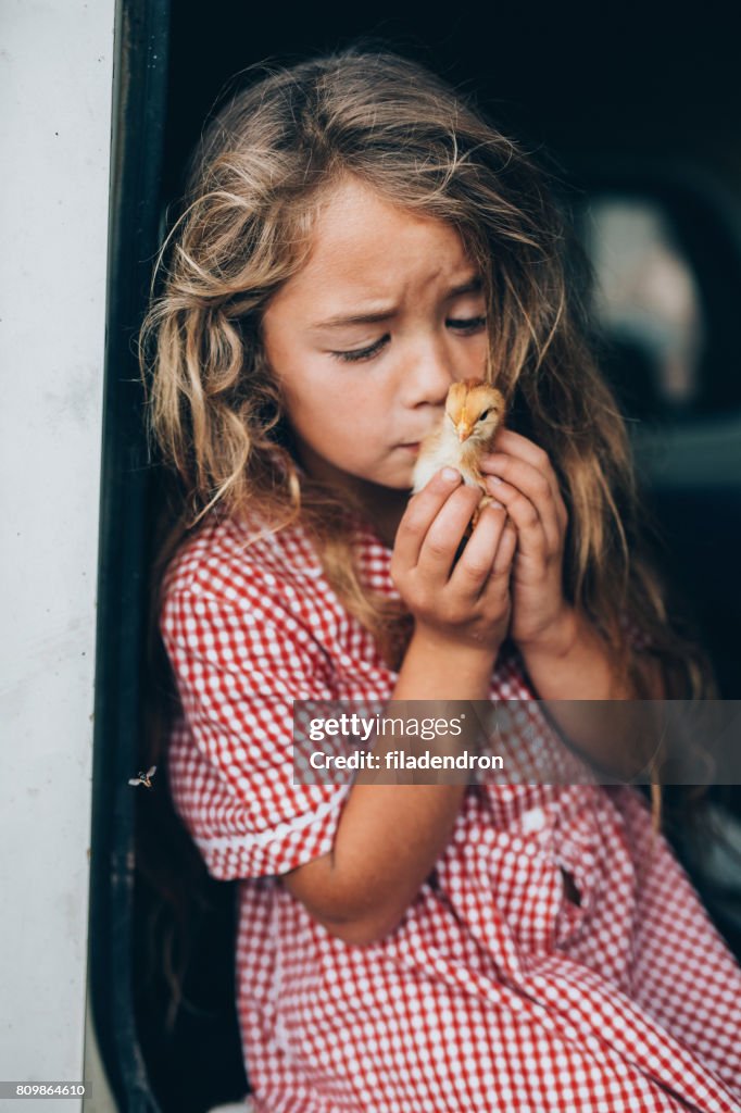 Girl kissing a little chicken