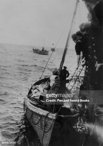 Ship rescuing survivors from a sunken merchant ship in the atlantic ocean.