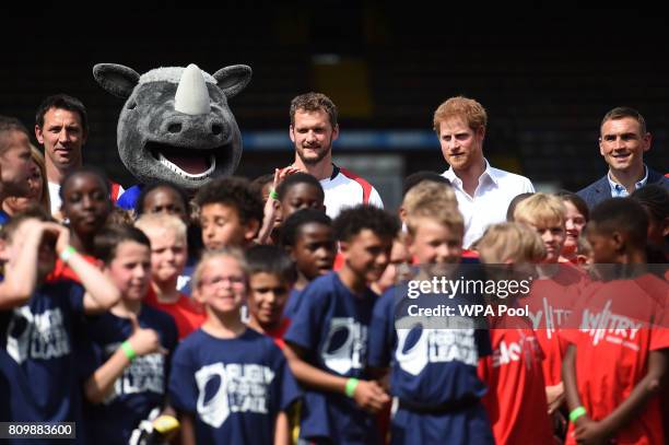 Britain's Prince Harry poses with mascot Ronnie the Rhino , professional rugby league player Sean O'Loughlin , former Leeds Rhino rugby league...