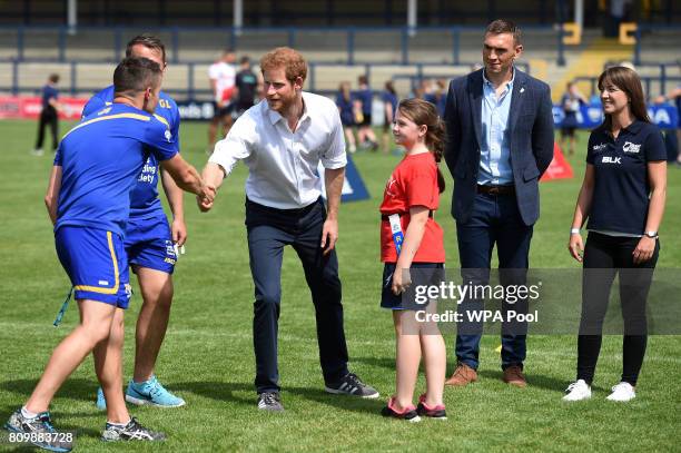 Britain's Prince Harry is accompanied by former Leeds Rhino rugby league player, Kevin Sinfield as he meets with children, coaches and players during...