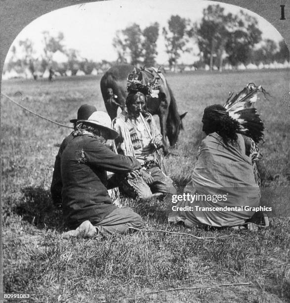 Stereoscopic photograph shows a Sioux peace pipe ceremony, early 20th century.