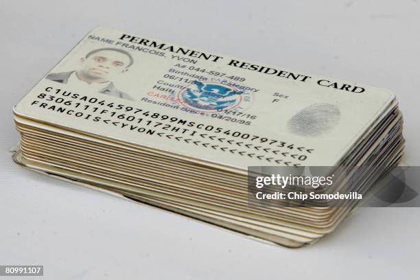 Permanent resident cards are stacked after being turned in by 25 people ahead of a natrualization ceremony on the National Mall May 5, 2008 in...