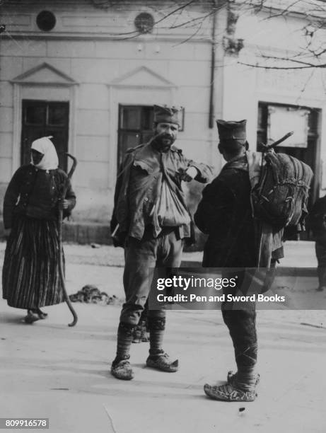 Wounded serbian soldier describing his experiences to a comrade in a street in Nisch.