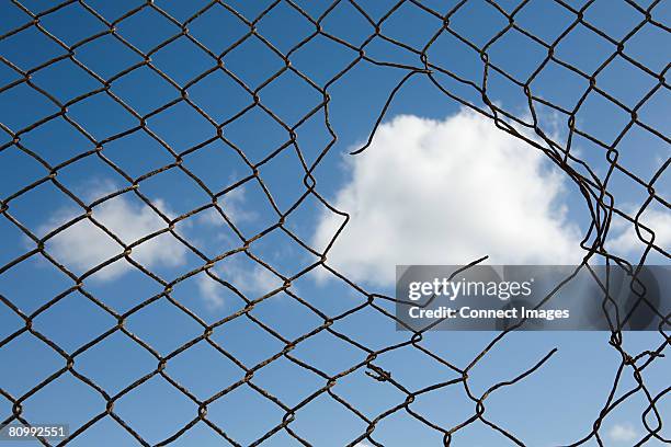 cloud through a broken fence - maschendrahtzaun stock-fotos und bilder