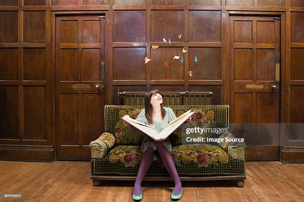 A teenage girl reading a large book