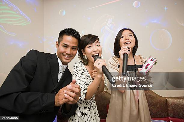 friends singing karaoke - karaoke stock pictures, royalty-free photos & images