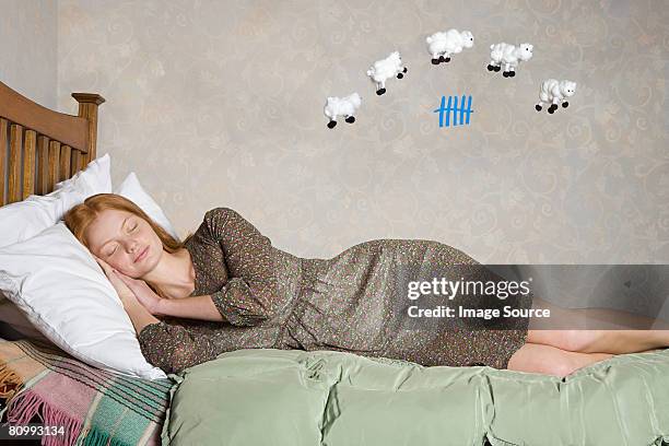 a young woman counting sheep - sleeping sheep stock pictures, royalty-free photos & images