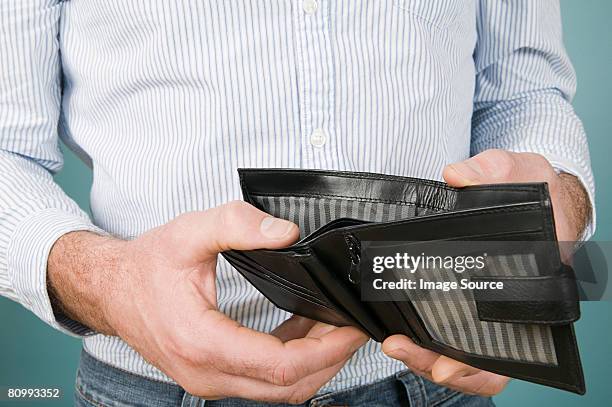 man holding empty wallet - empty wallet stock-fotos und bilder