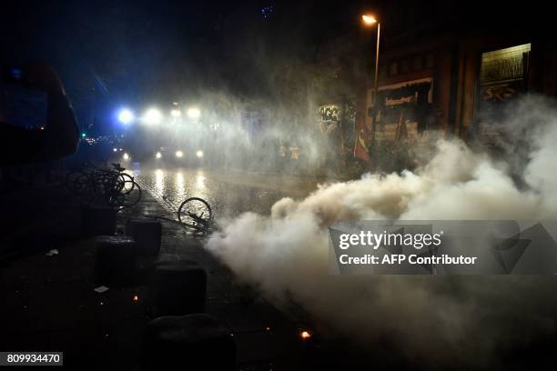 Riot police use water cannon to put of burning bins after the "Welcome to Hell" rally against the G20 summit in Hamburg, northern Germany on July 6,...