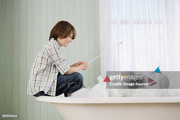 a boy fishing in a bathtub - boat in bath tub stock pictures, royalty-free photos & images