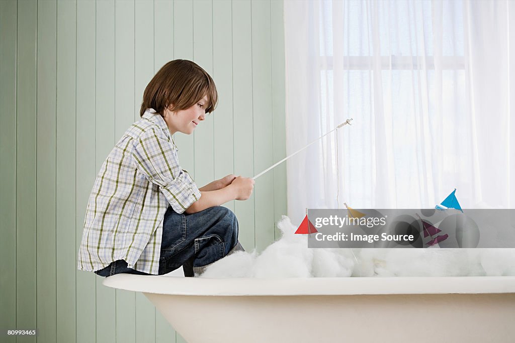 Um rapaz pesca em uma Banheira