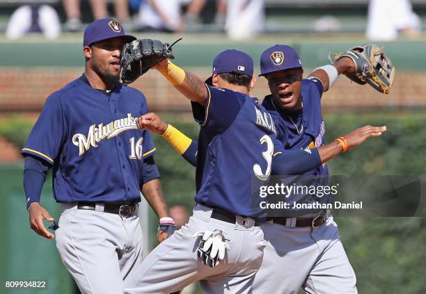 Domingo Santana, Orlando Arcia and Keon Broxton of the Milwaukee Brewers celebrate a win over the Chicago Cubs at Wrigley Field on July 6, 2017 in...
