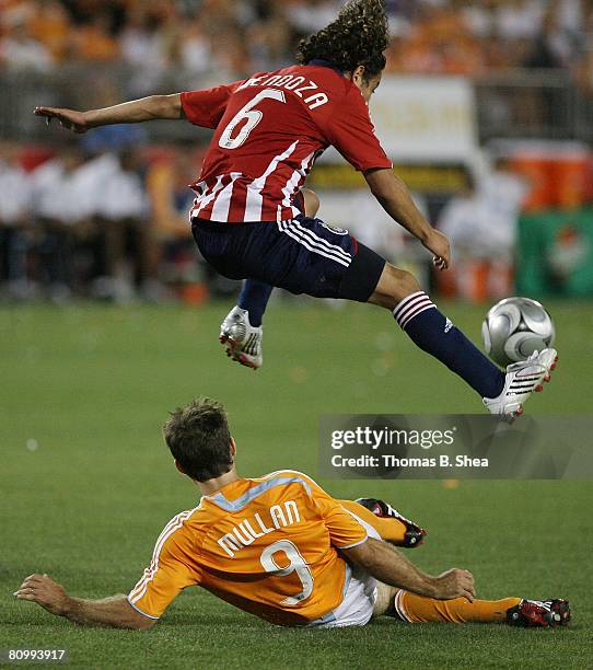 Brain Mullan of the Houston Dynamo slide tackles Francisco Mendoza of Chivas USA on May 3, 2008 at Robertson Stadium in Houston, Texas.