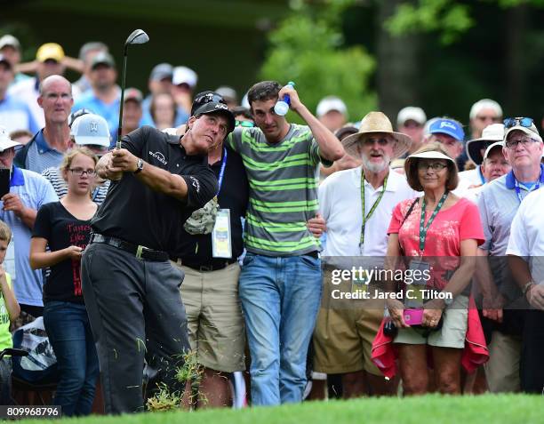 Phil Mickelson chips onto the 11th green after his ball hit a fan in the gallery during round one of The Greenbrier Classic held at the Old White TPC...