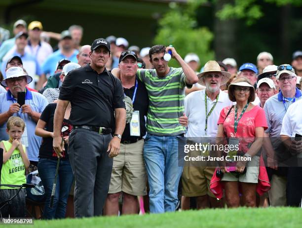 Phil Mickelson chips onto the 11th green after his ball hit a fan in the gallery during round one of The Greenbrier Classic held at the Old White TPC...