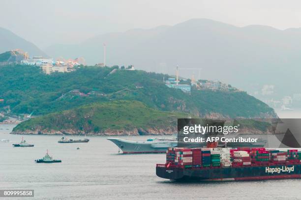 China's aircraft carrier, the Liaoning, sails past a cargo ship in the Lamma Channel as it arrives in Hong Kong territorial waters on July 7, 2017....