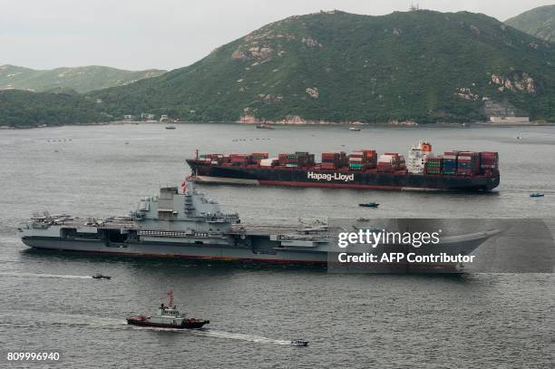 China's aircraft carrier Liaoning sails past a cargo ship as it arrives in Hong Kong on July 7, 2017. China's national defence ministry had said the...