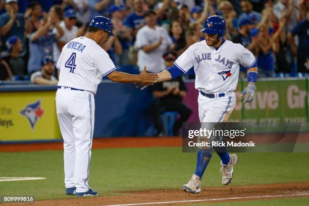 Toronto Blue Jays catcher Russell Martin rounds 3rd base and gets some congratulations from Toronto Blue Jays third base coach Luis Rivera after...