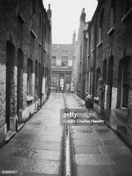 Mothers and children in a slum area of Stepney in the East End of London, 9th March 1946. London County Council is planning to transform the area as...