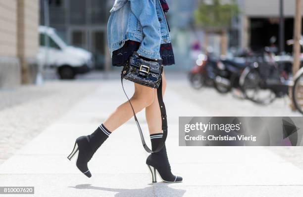 Alexandra Lapp wearing a mini lace dress in navy blue and heady red from Self-Portrait, a Roger Viv mini bag crafted in suede with waterjet cut...