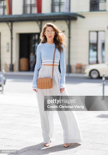 Alexandra Lapp wearing blue-white striped wide leg pants from Zimmermann, a baby blue cropped top from H&M, gold mirrored cat-eye sunglasses from...