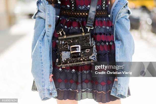 Alexandra Lapp wearing a mini lace dress in navy blue and heady red from Self-Portrait, a Roger Viv mini bag crafted in suede with waterjet cut...