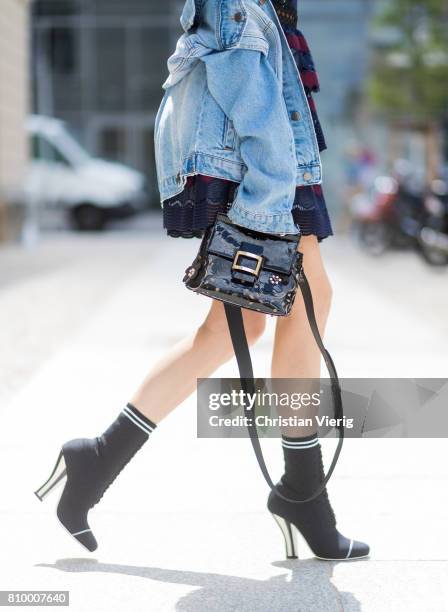 Alexandra Lapp wearing a mini lace dress in navy blue and heady red from Self-Portrait, a Roger Viv mini bag crafted in suede with waterjet cut...