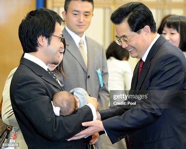 Chinese President Hu Jintao greets a baby, Reo Mukai, his father Akimitsu Mukai and mother Emi as he meets with his Japanese old friends and their...