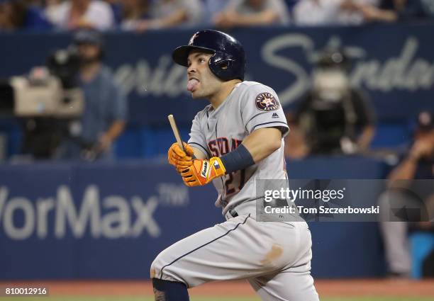 Jose Altuve of the Houston Astros hits an RBI single in the seventh inning during MLB game action against the Toronto Blue Jays at Rogers Centre on...