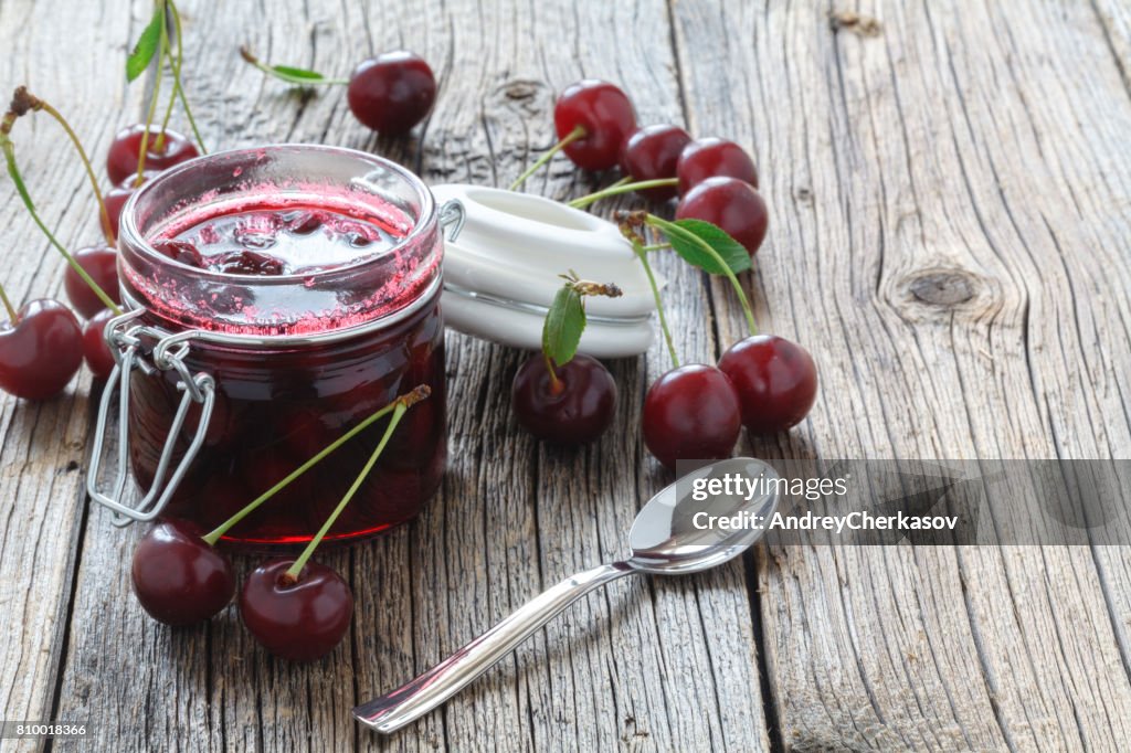 Cherry jam / cherry basket on wooden background
