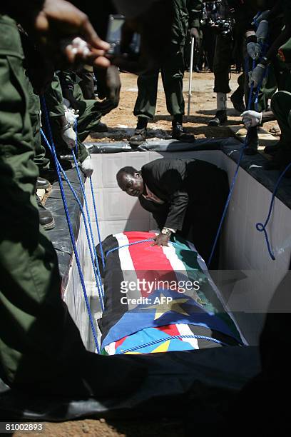 The flag draped casket containing the remains of South Sudan's late Defence minister Dominic Diem Deng is lowered into his grave on May 6, 2008 at...
