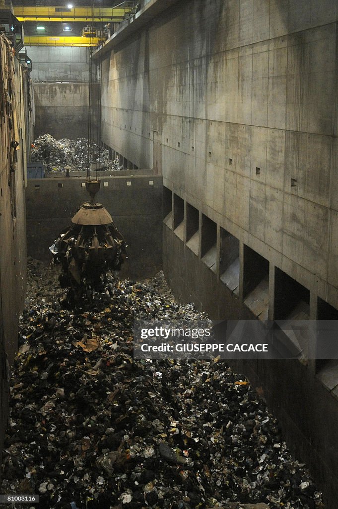 An excavator moves rubbish inside the Si