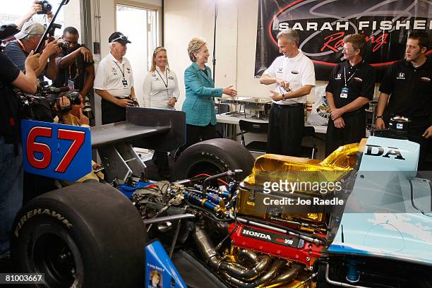 Democratic presidential hopeful U.S. Senator Hillary Clinton walks in with race car driver Sarah Fisher as she shows her the Indy race car during a...